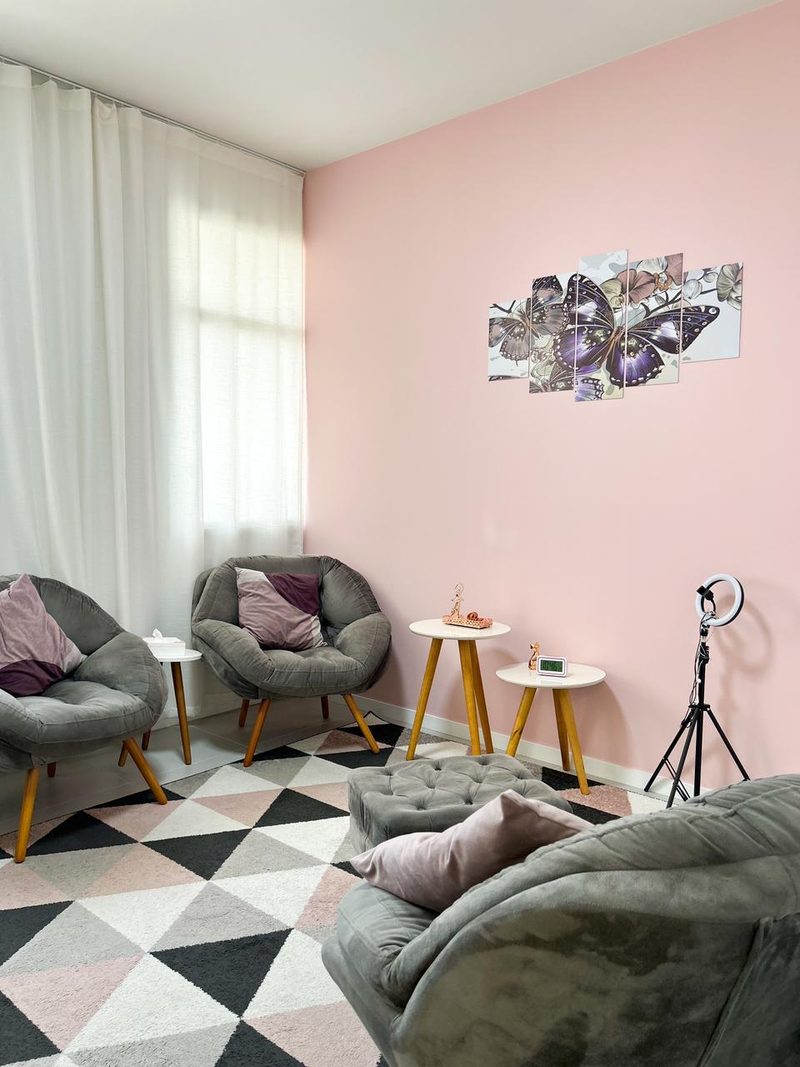 Sala de atendimento com parede rosa e quadro de borboletas