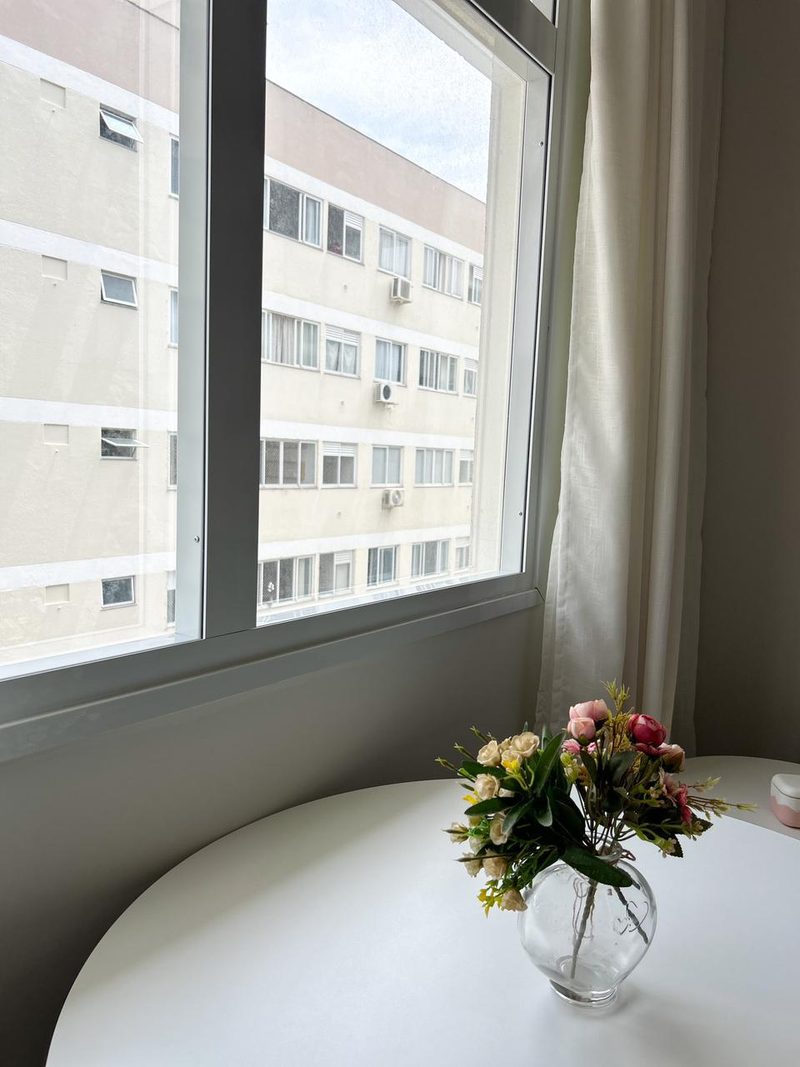 Mesa junto à janela com um arranjo de flores